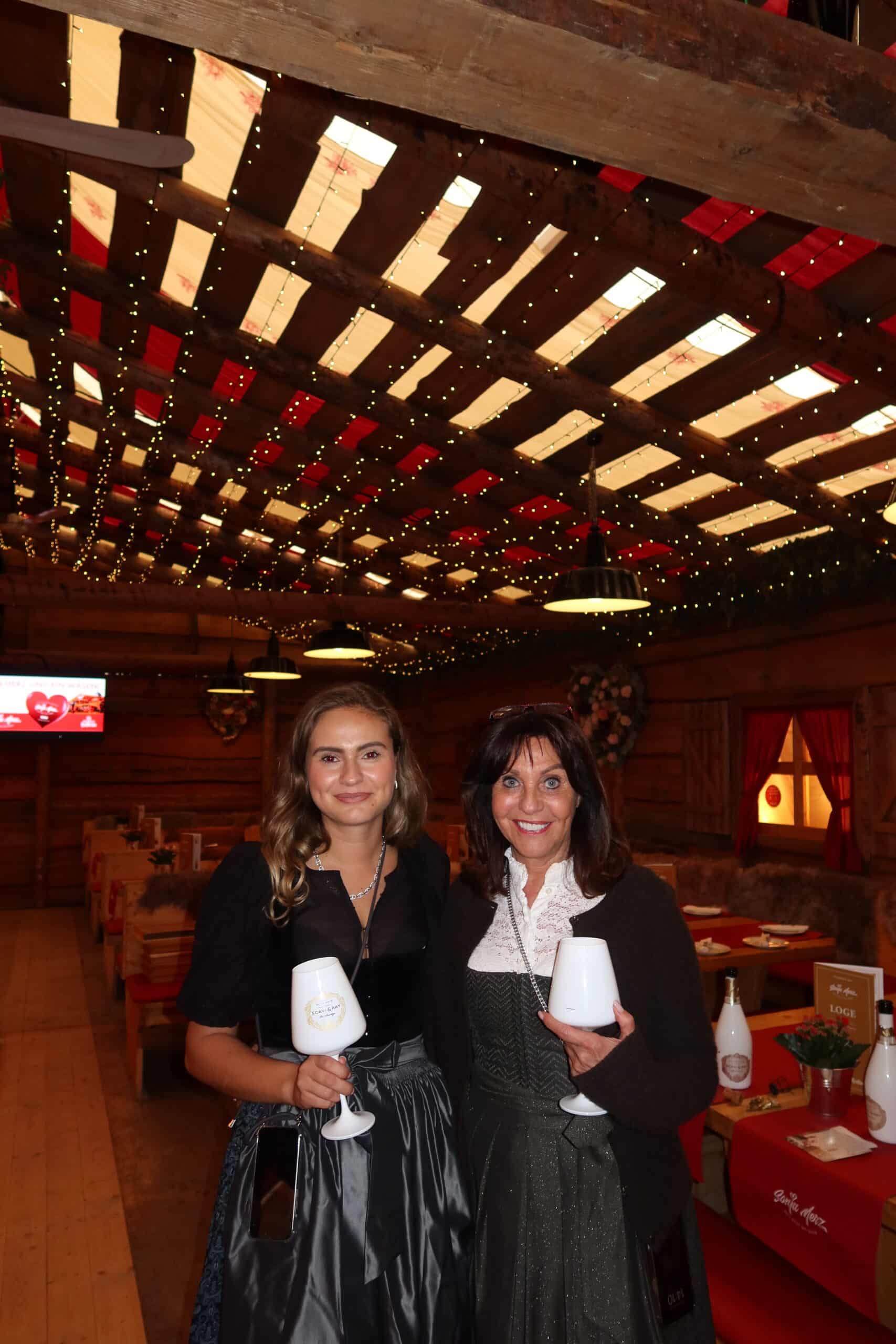 Gastgeberinnen Sonja Merz und Katharina Renz in der Loge des Festzelts mit Holzbalkendecke und Lichterketten
